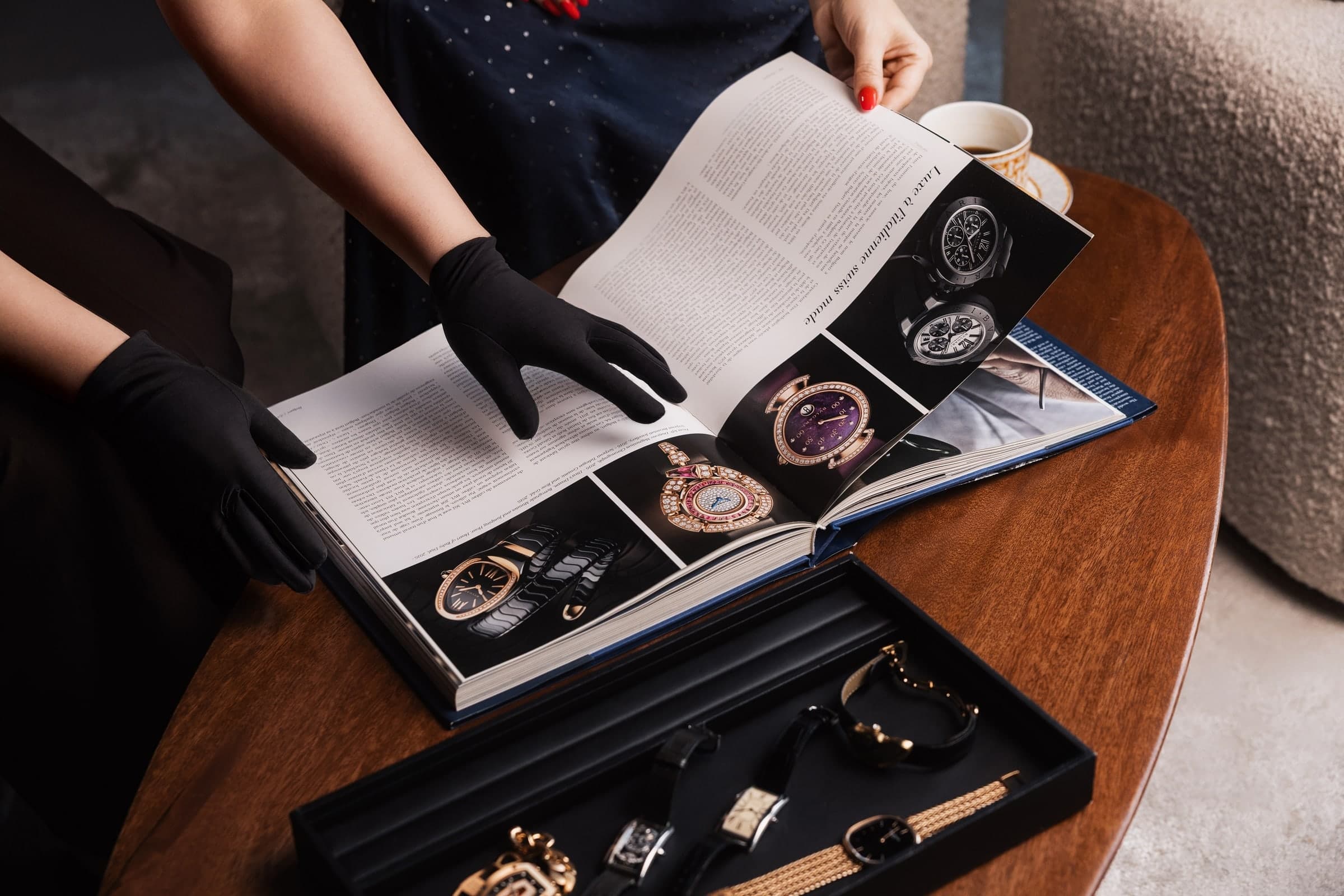 A Calliste specialist in white gloves with a watch book and a tray of watches