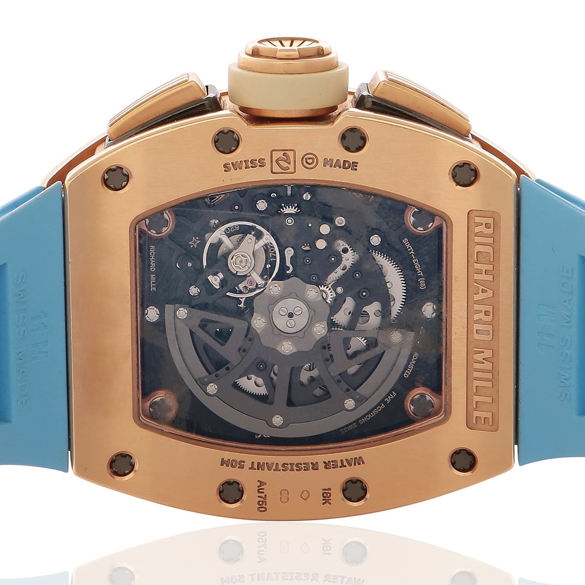 Richard Mille rose gold watch with skeleton dial and light blue rubber strap showing the crown.