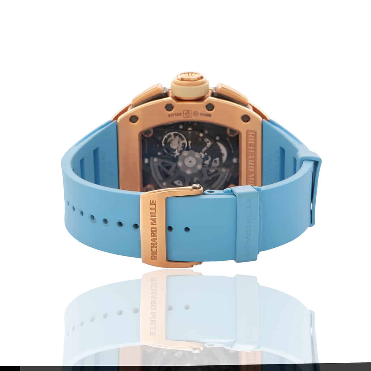 Richard Mille rose gold watch with skeleton dial, light blue rubber strap & clear back.