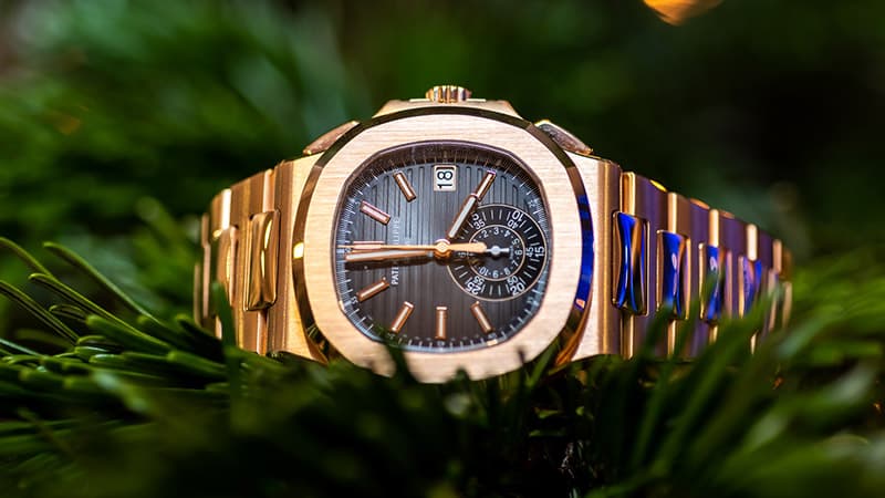 Close up of yellow gold Patek Philippe watch with dark dial