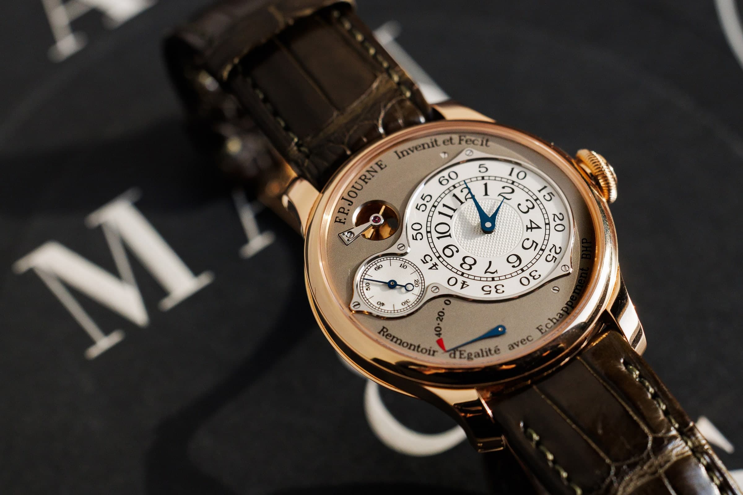 F.P. Journe Chronomètre Optimum in rose gold, on a dark leather-bound book